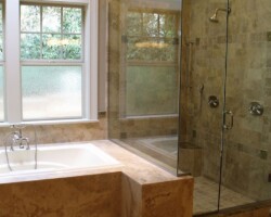 bathroom countertop with tub and glass enclosure